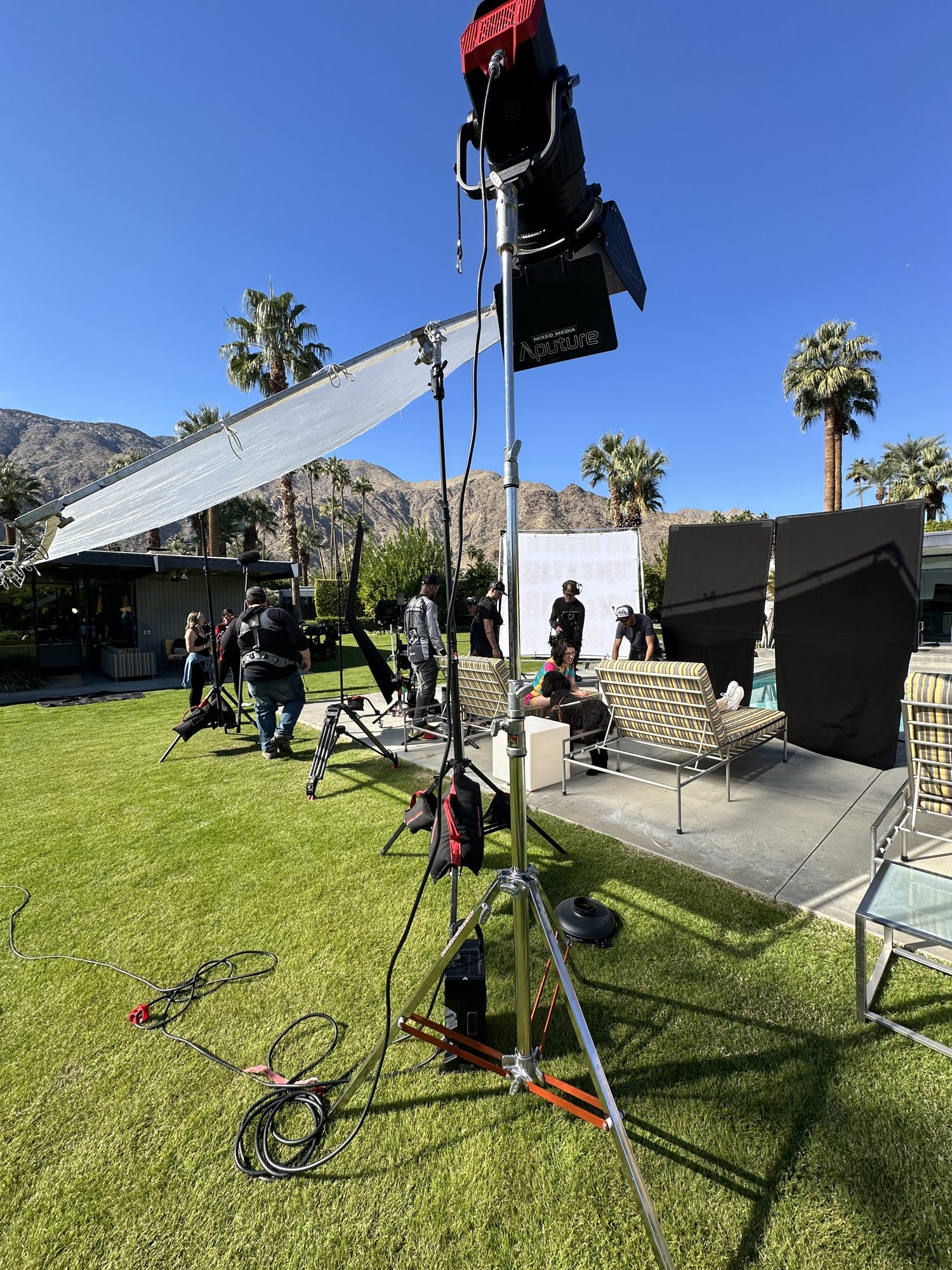 Crew building out a set beside a midcentury pool