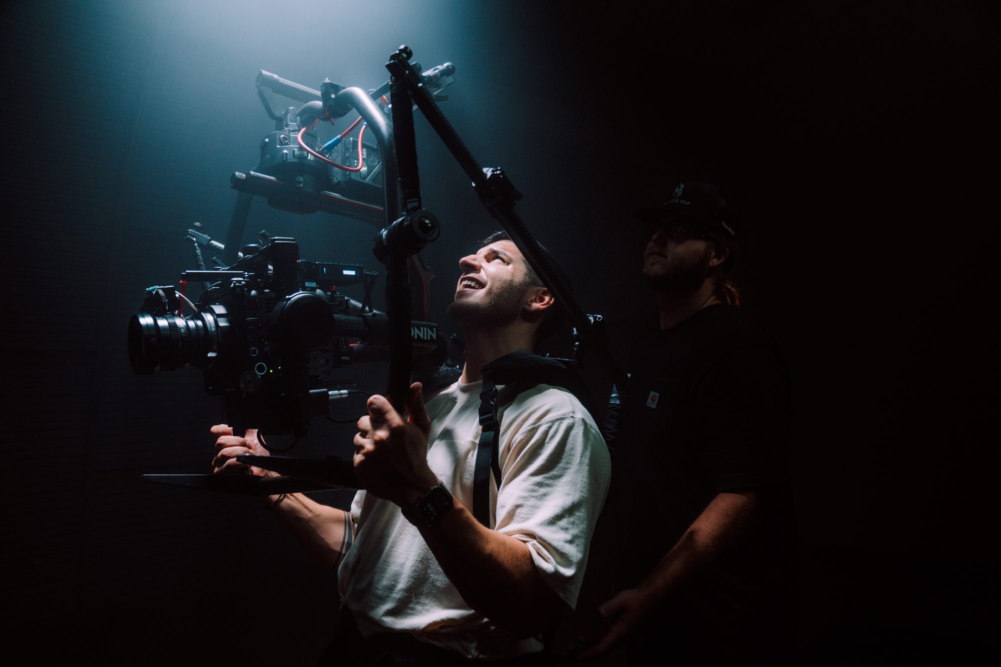 Camera operator adjusting a gimbal rig between takes