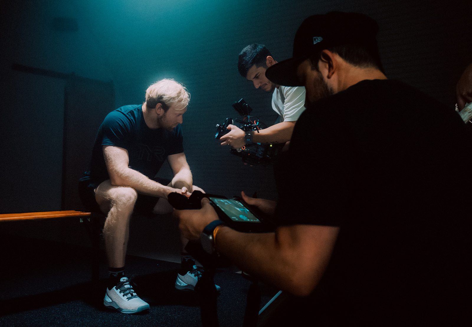 Reviewing a take with an athlete in a dim locker room