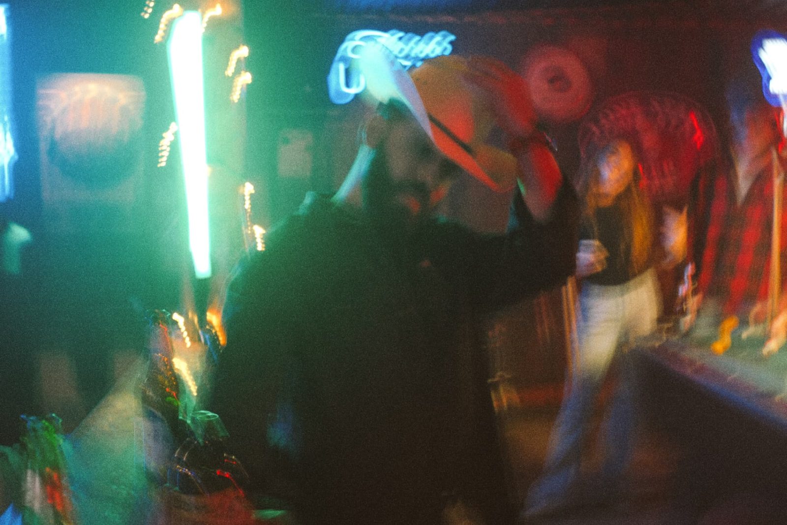 Crew working under green and red neon light on a night set