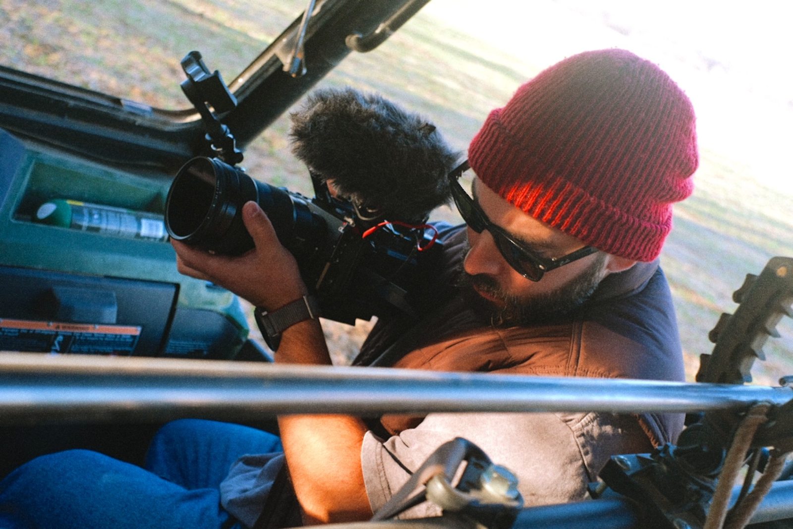 Operator running a rigged camera from a vehicle seat
