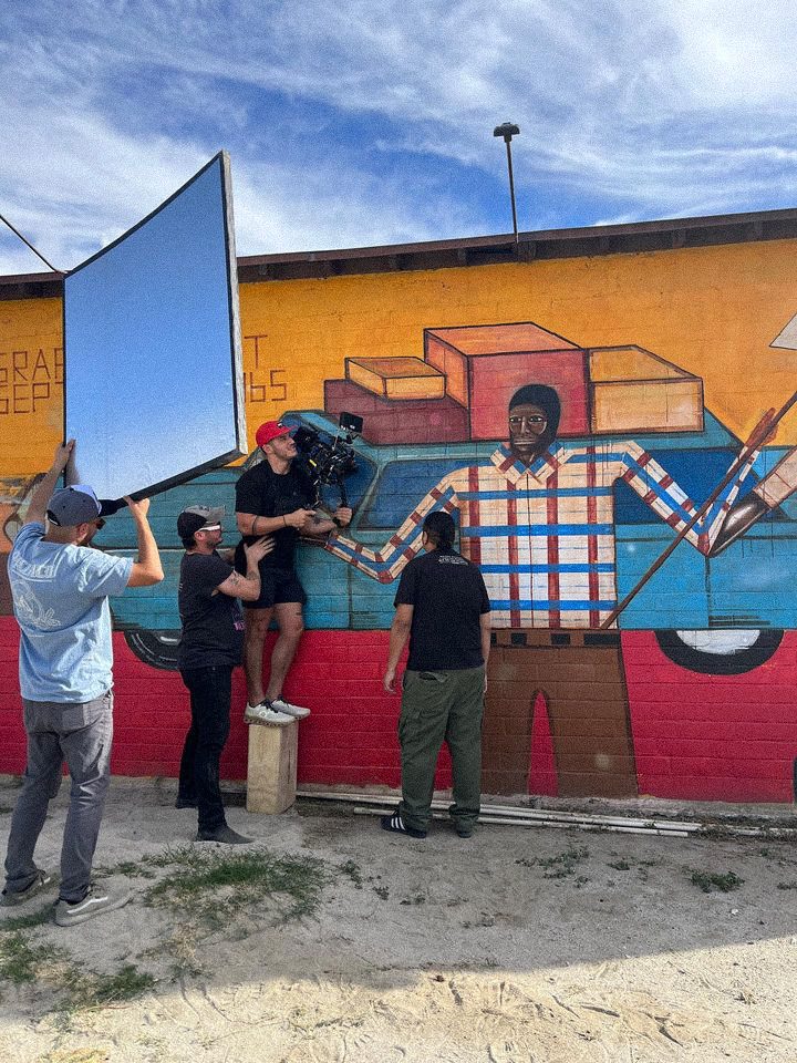 Crew raising a bounce against a painted mural